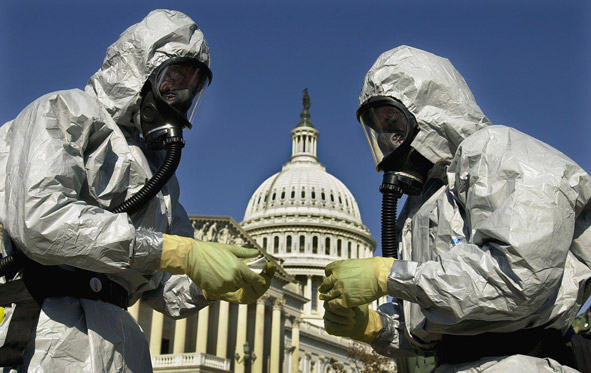 People in biohazard suits in front of the Capitol