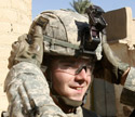 Soldier adjusting another's helmet