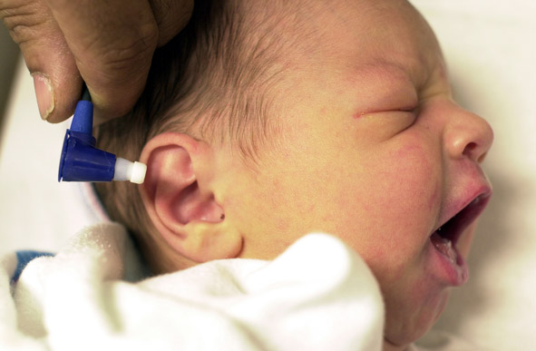close up of newborn receiving hearing test