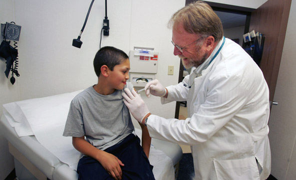 young boy receiving a vaccine from a nurse