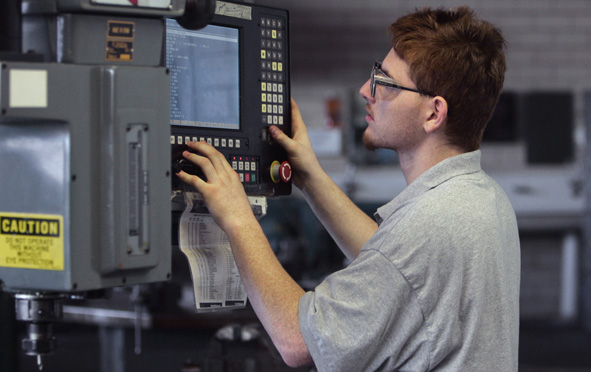 man operating computer-numerical controlled machine
