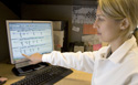 forensic scientist explainig DNA search information on a computer screen