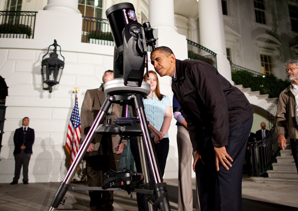 President Obama peers into a telescope during the Astronomy Night event on the South Lawn of the White House