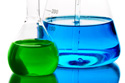 two scientific beakers, one with green liquid, another with blue liquid