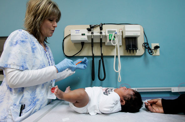 A medical assistant prepares a vaccination for a two-month-old during a wellness check at Children's Hospital in Minneapolis, Monday, Dec. 18, 2006.